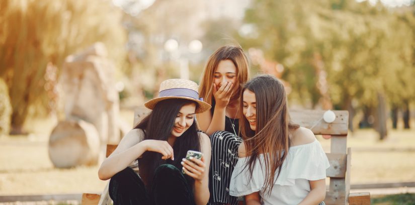 stylish friends Three beautiful stylish girls in hats sitting in a summer park on pallets